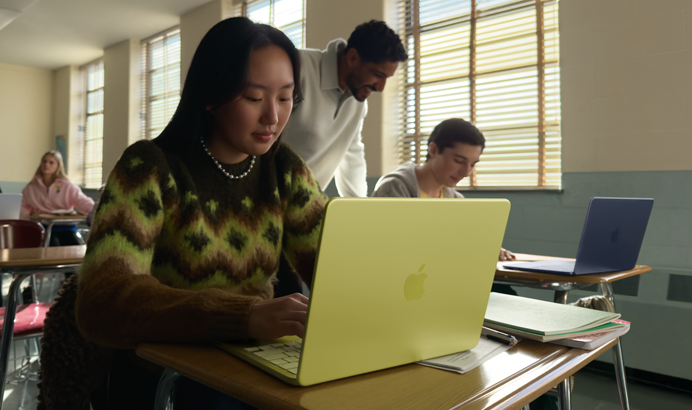 Een student gebruikt MacBook Neo, kleur Citrus, zonder netsnoer in een klaslokaal